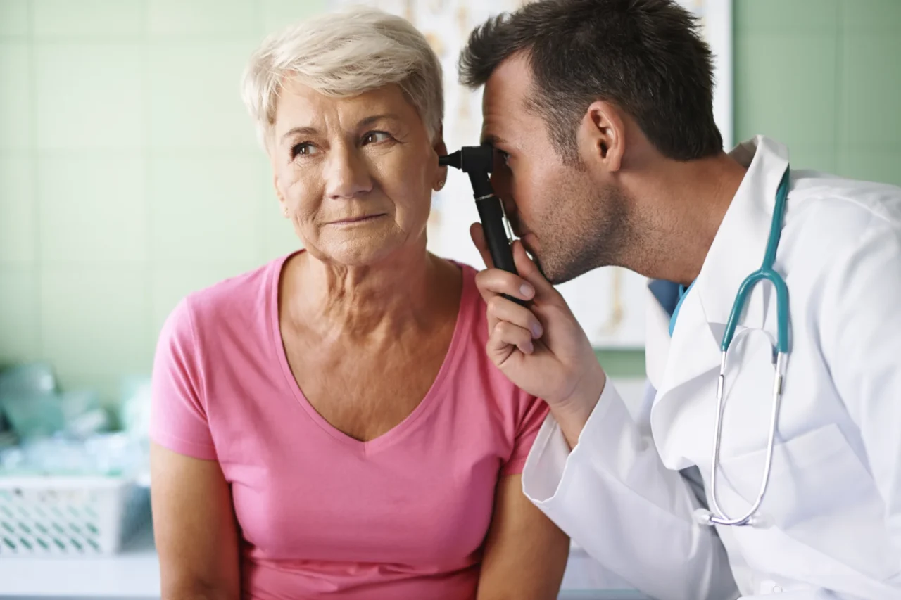 Senhora durante exame de ouvido com otoscópio, em consulta de otorrinolaringologia